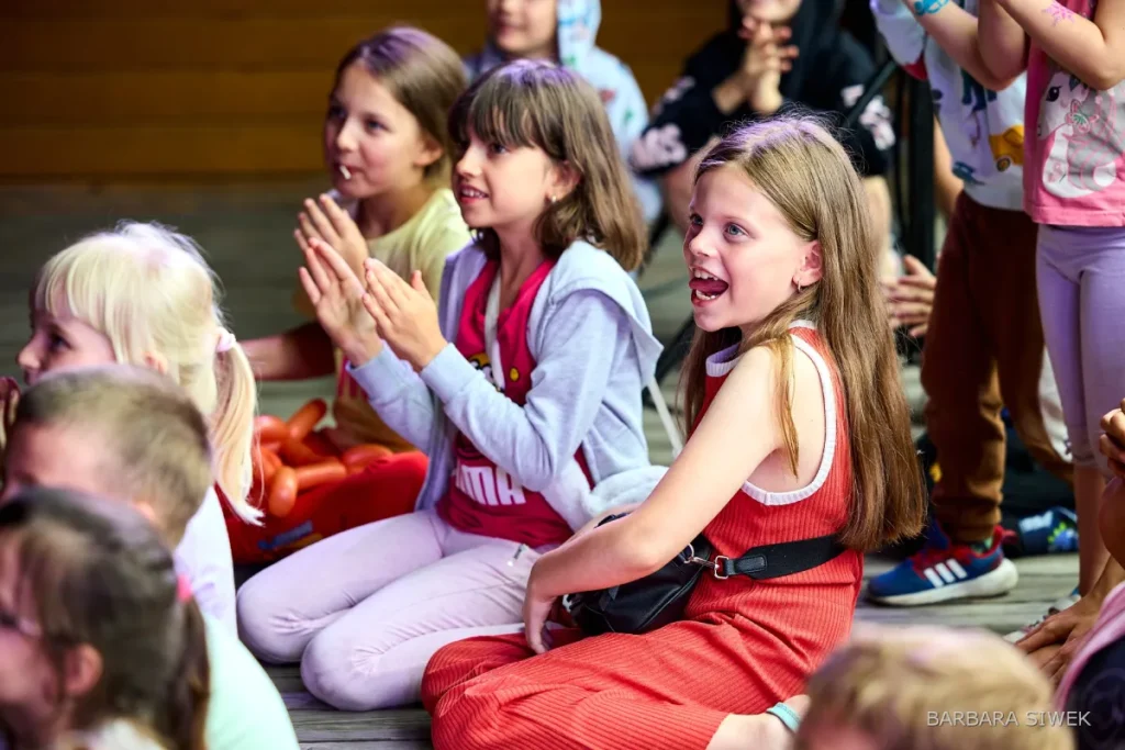 Dzieci śmieją się podczas występu klauna dla dzieci i dorosłych