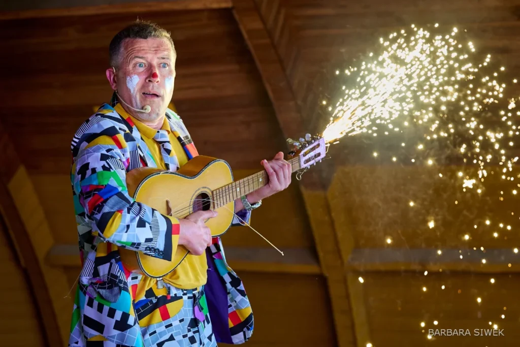 Bogdan Michalec gra na gitarze z efektami pirotechnicznymi podczas eventu firmowego